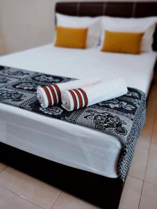 马六甲Muslim 2 Stay的一张带两条毛巾和两个枕头的床