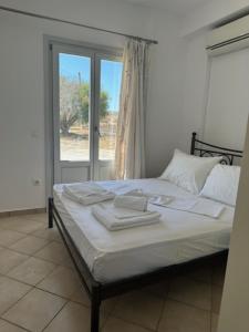 Agia ParaskeviIFESTIA HOUSE的一间卧室配有一张带白色床单的床和一扇窗户。