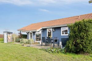 伦德Summer House With Sauna Near Flle Strand,的院子里带桌子的蓝色房子