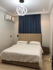 杜拉特阿拉尔Distinctive chalet in Dur.Marina的卧室配有一张带吊灯的大型白色床。