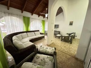 喀巴里特Villa Ramos - Private Beachfront with a View的客厅配有白色沙发和绿色窗帘