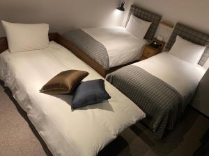 东京Hotel Resol Stay Akihabara的客房内的两张单人床和枕头