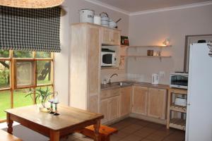 MalgasPotteberg Guest Farm的厨房配有木制橱柜、桌子和冰箱。