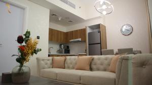 阿布扎比Chalet 2BR Duplex Apartment的带沙发的客厅和厨房
