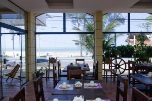 马卡埃贝拉特里克斯酒店的一间带桌椅的餐厅,享有海滩美景