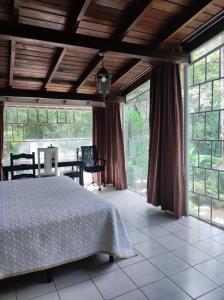 El ManzanilloVILLA ELENA un refugio en el bosque的一间卧室设有一张床和大窗户