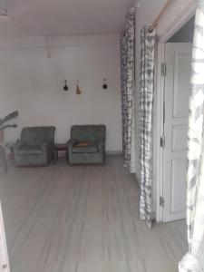 迪马普尔Moa's Nest的客厅配有两把椅子和一扇门