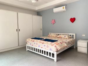芭堤雅市中心south pattaya,5BR modern villa的卧室配有一张床,墙上有心