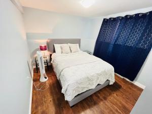 Lower SackvilleBasement unit with 2 bedrooms, bath and living area的一间小卧室,配有床和蓝色窗帘