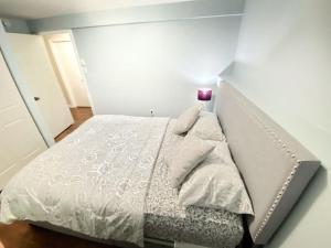 Lower SackvilleBasement unit with 2 bedrooms, bath and living area的小卧室配有带白色棉被的床