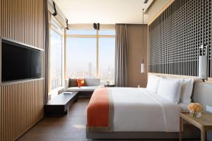 广州广州卓美亚酒店的酒店客房配有床、沙发和电视。