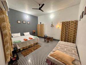 AyodhyaShanti Vatika的一间卧室配有两张床和吊扇