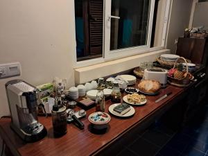 Phumĭ Kâmpóng ÂmpĭlLa maison bleue BTB的一张桌子,上面有食物和咖啡壶