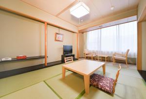 小樽朝里川温泉ホテル的配有桌椅和电视的客房