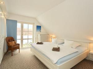 于斯德Strandhuus Modern retreat的卧室配有一张白色大床和一把椅子