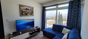 危地马拉Apartamento Parada 50的客厅设有蓝色的沙发和大窗户