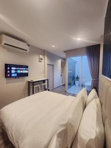 Ban Khlong Lat Bua KhaoSkyline Resort的卧室配有一张白色大床和电视。