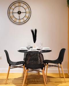 伯明翰TQ luxurious 2 bed flat的餐桌、椅子和墙上的时钟