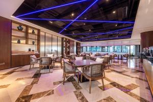 重庆重庆大世界君亭酒店(解放碑店)的一间配备有桌椅和蓝光的用餐室