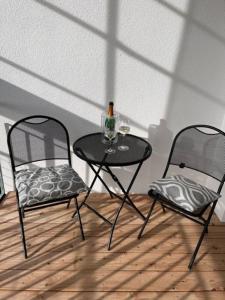马克多夫Lieblingsplatz-Bodensee的两把椅子和一张桌子,上面装有一瓶葡萄酒