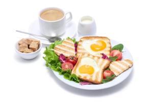 新德里Hotel TU Casa (Stay near International Airport)的鸡蛋三明治和咖啡的盘子