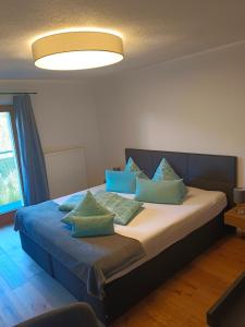 布伦纳山口格里斯伯格霍夫豪斯酒店的一间卧室配有一张带蓝色枕头的床