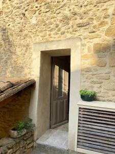 教皇新堡Maison de village panoramique的通往石头建筑的门,有两株盆栽植物