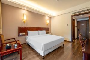 张家界Hunan New Pipaxi Hotel的卧室配有一张白色的大床和一张桌子