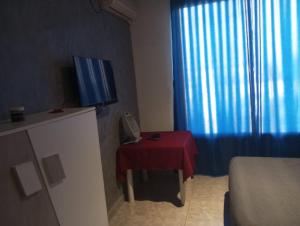 Hammamet SudVILLA BELLA VITA HAMMAMET的小房间设有红色桌子和电视