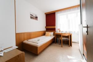 Konnersreuth维西斯罗斯酒店的小房间设有一张床和一张书桌