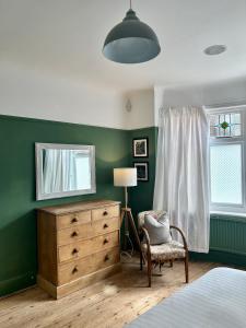 伯恩茅斯Palm - Bournemouth的一间卧室配有梳妆台、镜子和椅子