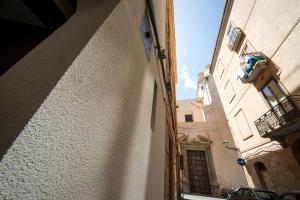 特拉帕尼B&B Cantiere dell'anima - Rooms of art的狭窄的小巷,设有建筑和阳台