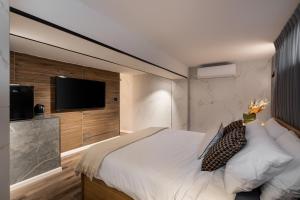 特拉维夫Mulan Hotel的一间卧室配有一张大床和一台平面电视