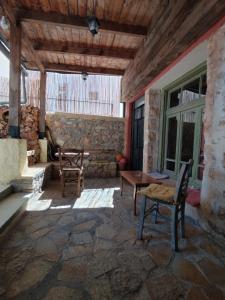 干尼亚Chania Hostel Youth的庭院设有两把椅子和一张桌子,还有石墙