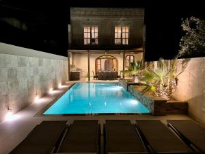Santa LuċijaTa Lucija - Luxurious 6 Bedroom/En suite Villa - Pool / AC的夜间在房子前面的游泳池