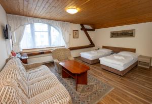 日恰尼中枢膳食公寓的客厅配有两张床、一张沙发和一张桌子