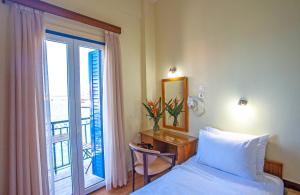 干尼亚卢西亚酒店 的一间卧室配有一张床和一张带窗户的书桌