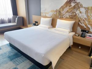 上海途客酒店（上海虹桥枢纽延安西路店）的一张大白色的床,位于酒店客房内
