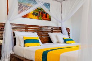 贝岛Long Beach Resort, Nosy Be的一间卧室配有黄色和蓝色枕头的床
