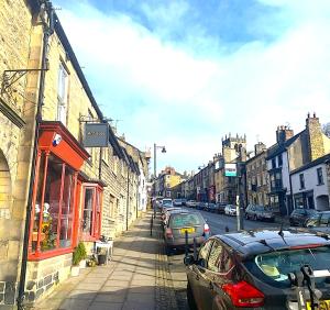 巴纳德城堡Spacious Georgian Apartment, Central Barnard Castle.的一条城市街道上,街上有汽车停放