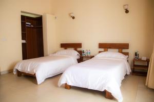 安齐拉贝Mahafaly Hotel & Resort的客房内的两张床和白色床单