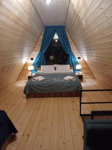 SnoPanorama cottages in Sno的一间卧室配有一张蓝色窗帘的床