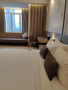 云顶高原Windmill Upon Hills Premium Suite By Rapi Stay的酒店客房配有一张带枕头的大型白色床。