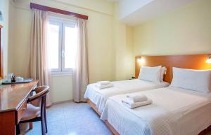 干尼亚卢西亚酒店 的一间卧室设有两张床、一张桌子和一个窗口。