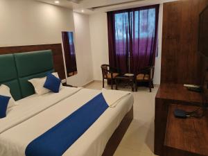 新德里Hotel D Tark Near IGI Airport的卧室配有床、椅子和窗户。
