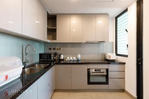 胡志明市Exclusive D1mension in District 1 3BR Apartment FreePoolSaunaGym的厨房配有白色橱柜和水槽