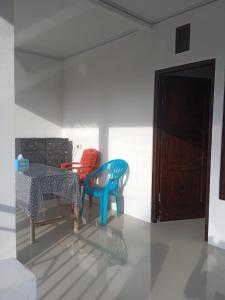 RiungRiung Tiga Empat Tujuh Guesthouse的一间带两把椅子和一张桌子的用餐室