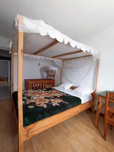 塔那那利佛Chez Jeanne Chambre d'Hôte的一间卧室配有一张木床和天篷