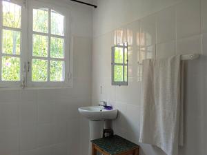 塔那那利佛Chez Jeanne Chambre d'Hôte的白色的浴室设有水槽和窗户。