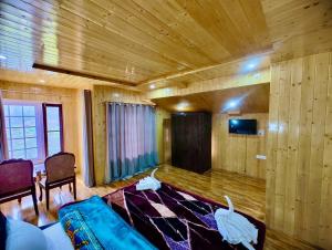 帕哈尔加姆Lady Pahalgam Resort Operated By Zaara Resorts的客厅配有蓝色的沙发和电视